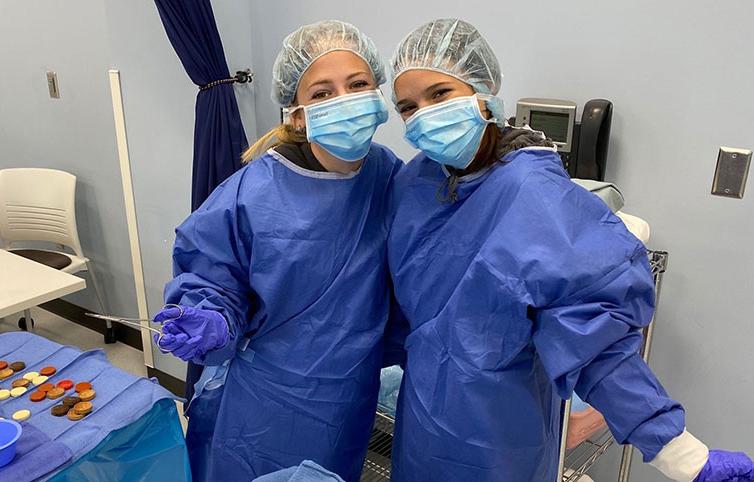 两名高中生在Anoka Tech外科技术实验室的手术训练营