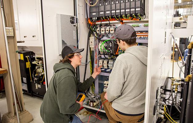 两名学生在安诺卡技术学院学习服务技术员设备.
